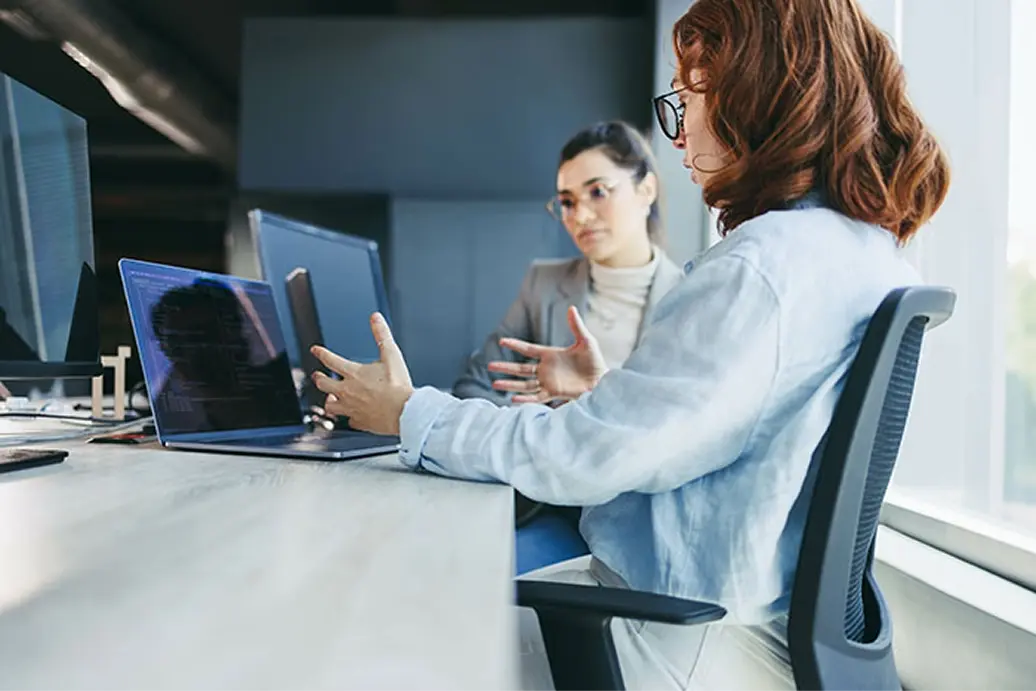 Colleagues collaborating around a laptop