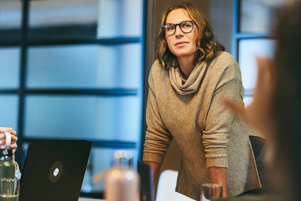 Woman standing at meeting table with hands on the table