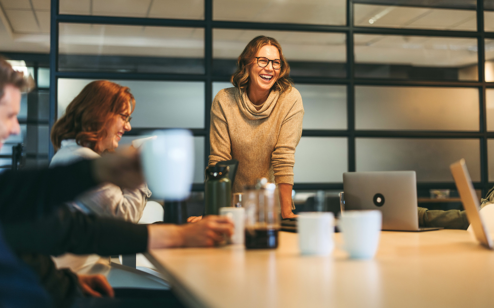 Woman standing at table with colleagues at a business meeting