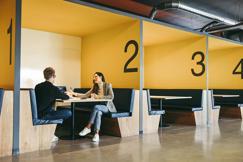 People sitting at a meeting table with numbers on the wall