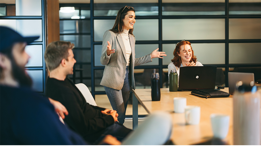 person speaking at meeting at table with other people attending