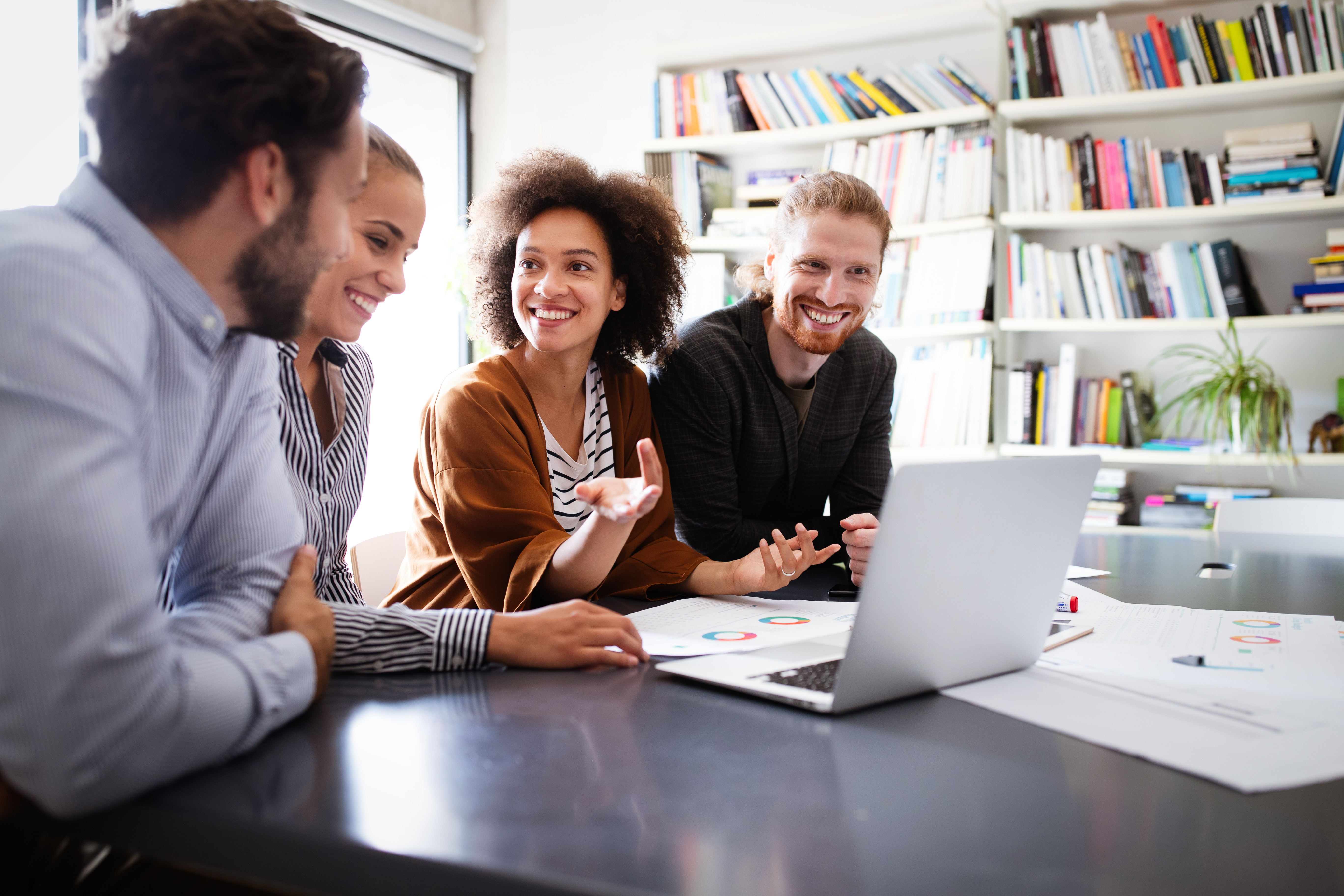 Group of people meeting at a table with a laptop